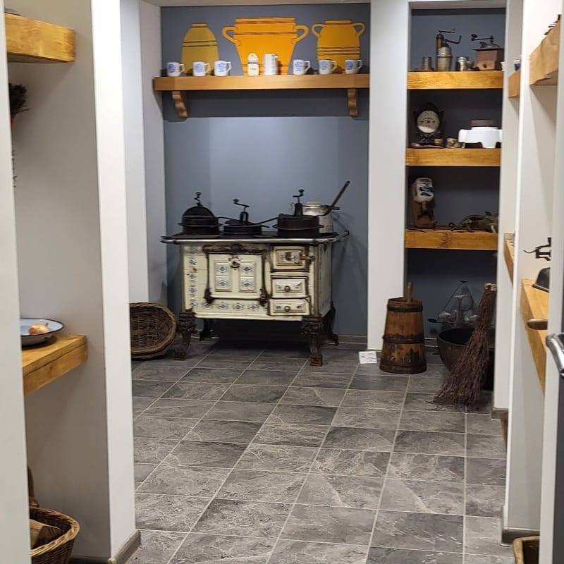 Tradycyjna mazurska kuchnia w muzeum – zabytkowy piec i sprzęty codziennego użytku ukazujące życie dawnych mieszkańców Mazur.