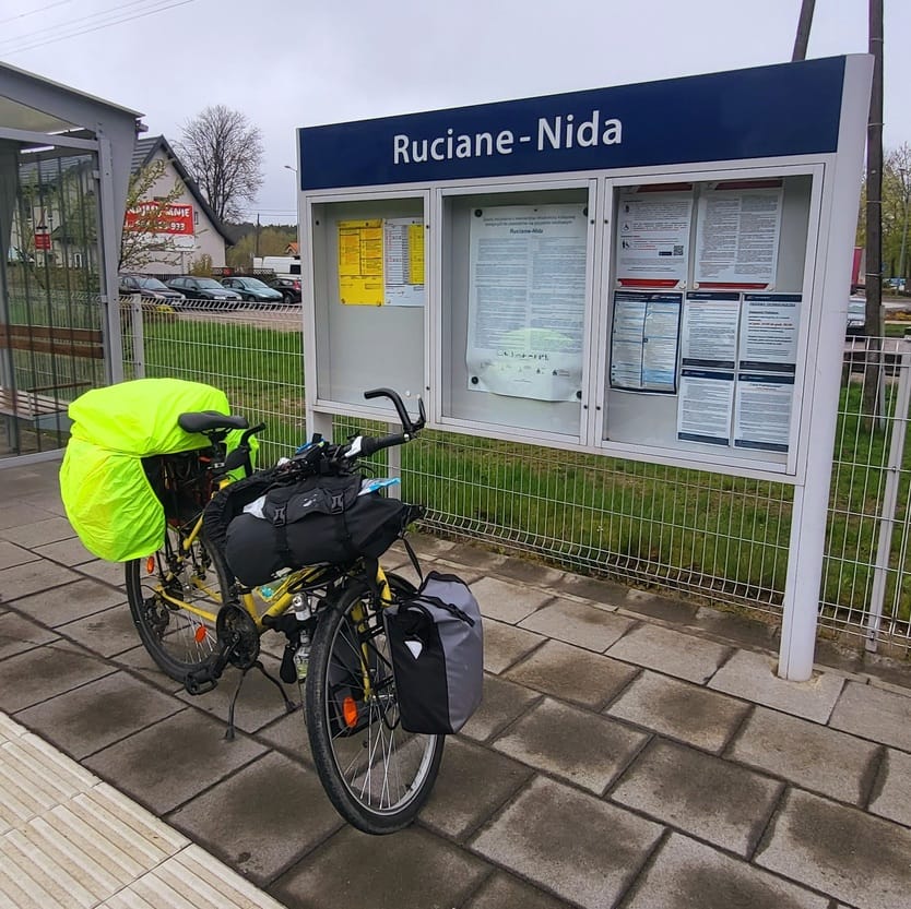 Rower turystyczny z sakwami zaparkowany na stacji kolejowej Ruciane-Nida – punkt startowy Mazurskiej Pętli Rowerowej.
