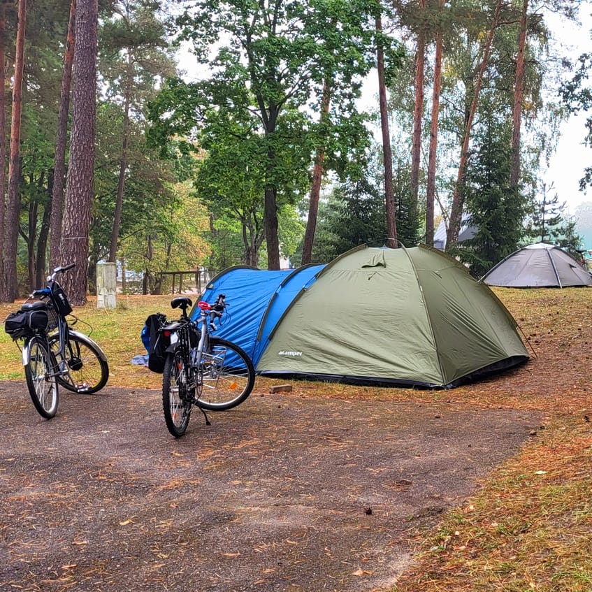 Pole namiotowe na Mazurach z namiotami i rowerami – idealne na trasie Mazurska Pętla Rowerowa.