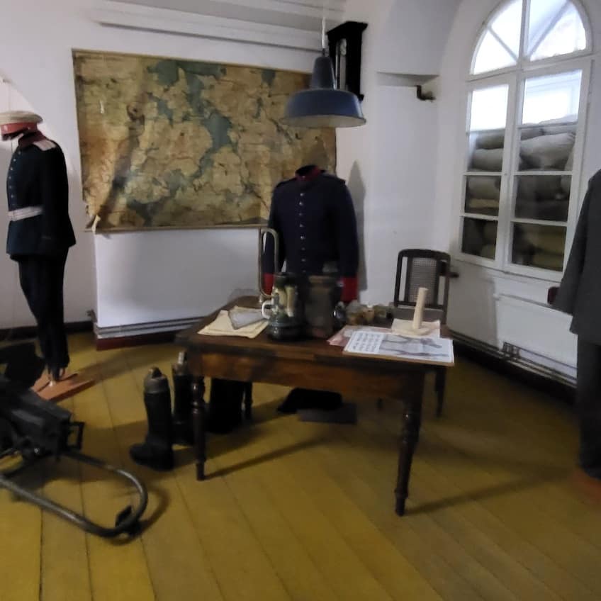 Mazurska Pętla Rowerowa: wnętrze Twierdzy Boyen z mundurami, stołem sztabowym i mapą regionu.