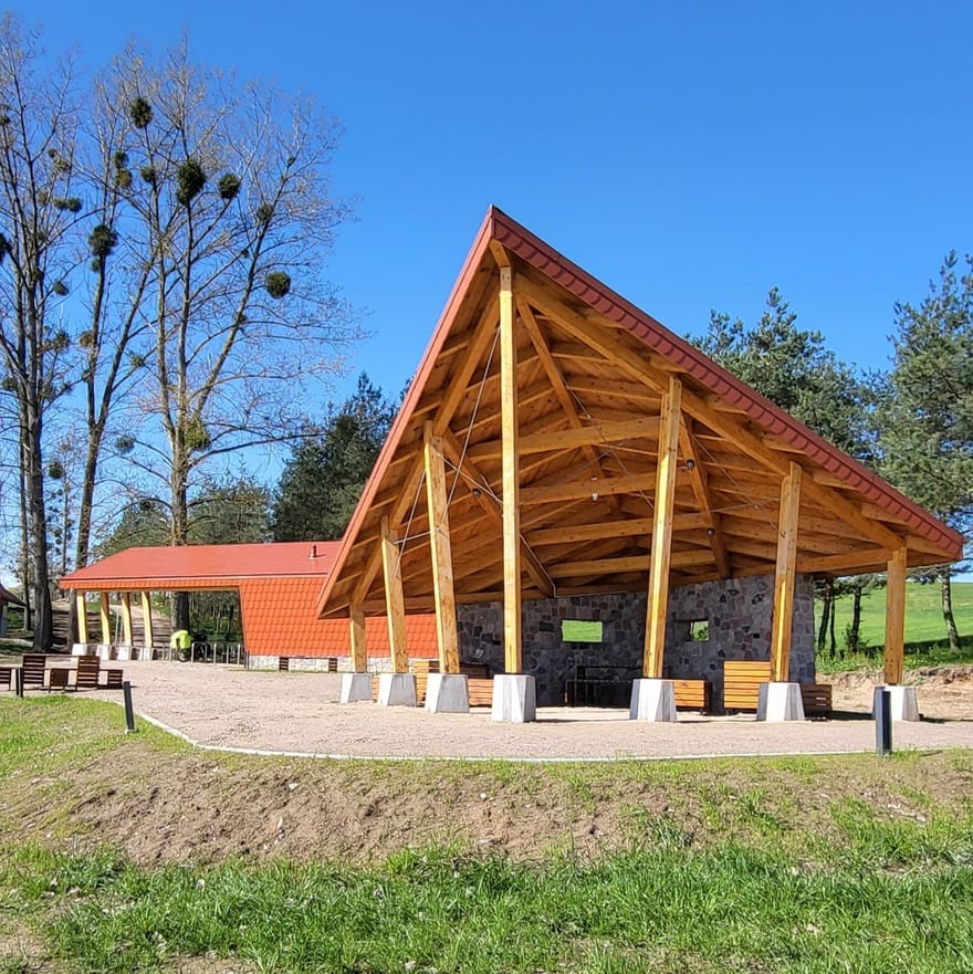 Miejsce Obsługi Rowerzystów (MOR) na Mazurskiej Pętli Rowerowej, z drewnianą wiatą i miejscami do odpoczynku.